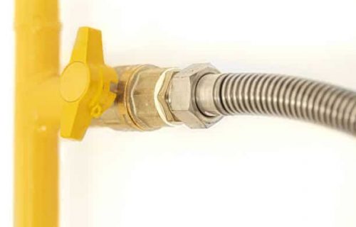 Yellow gas pipe with a valve. White background. Space for text.